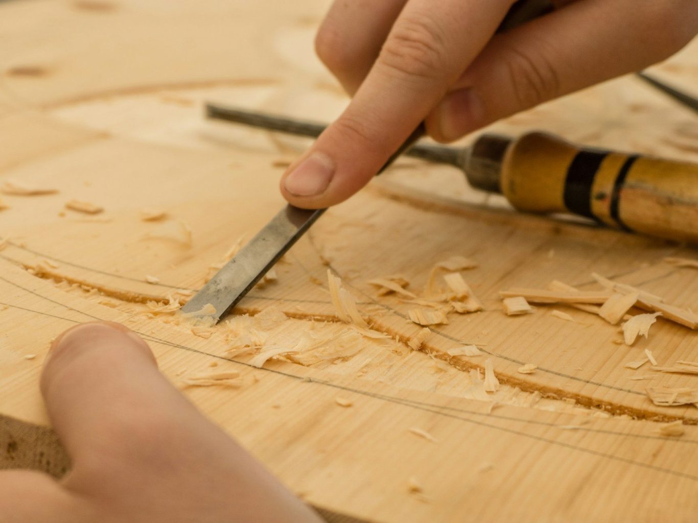 Craftsperson shaping timber by hand with a chisel