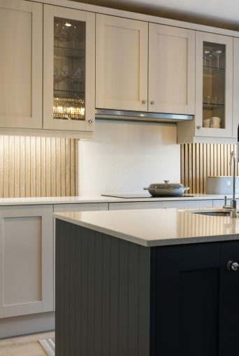 Painted shaker kitchen with glass display cupboards and a dark island