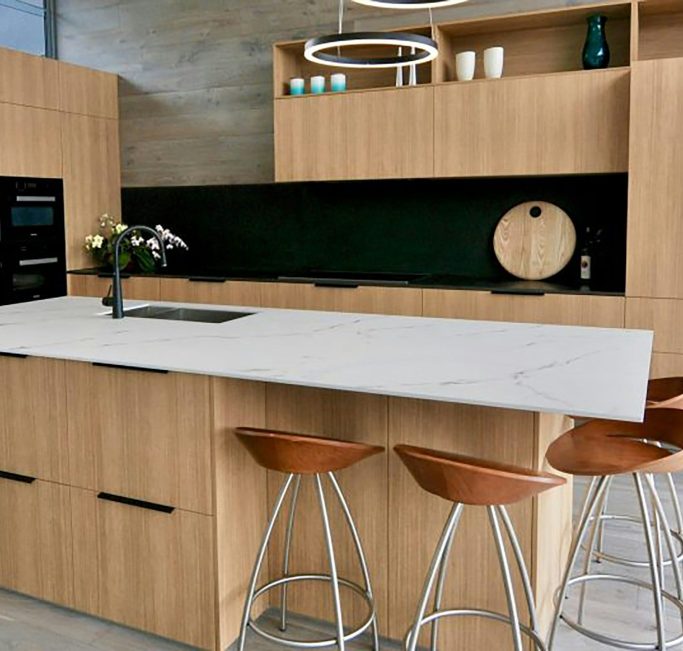 Natural oak kitchen with marble island and black recessed splashback